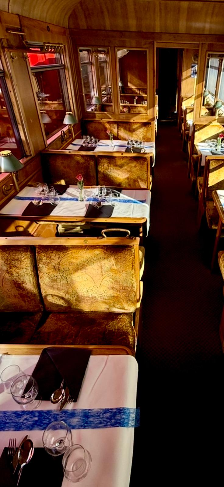 Fine Dining wagon with burr-walnut panelling, brocade banquettes and tables laid with linen and glassware