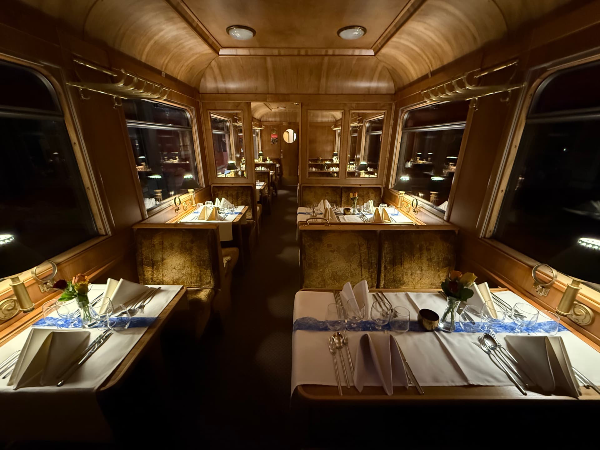 Fine Dining wagon at night, brocade banquettes and laid tables running the length of the carriage