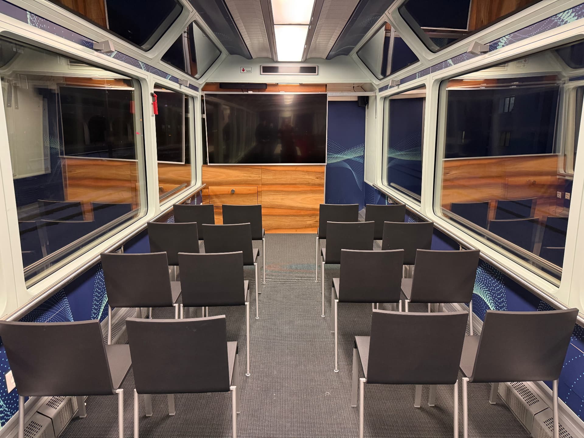 Panorama wagon laid out theatre-style with rows of chairs facing a screen and glass roof windows