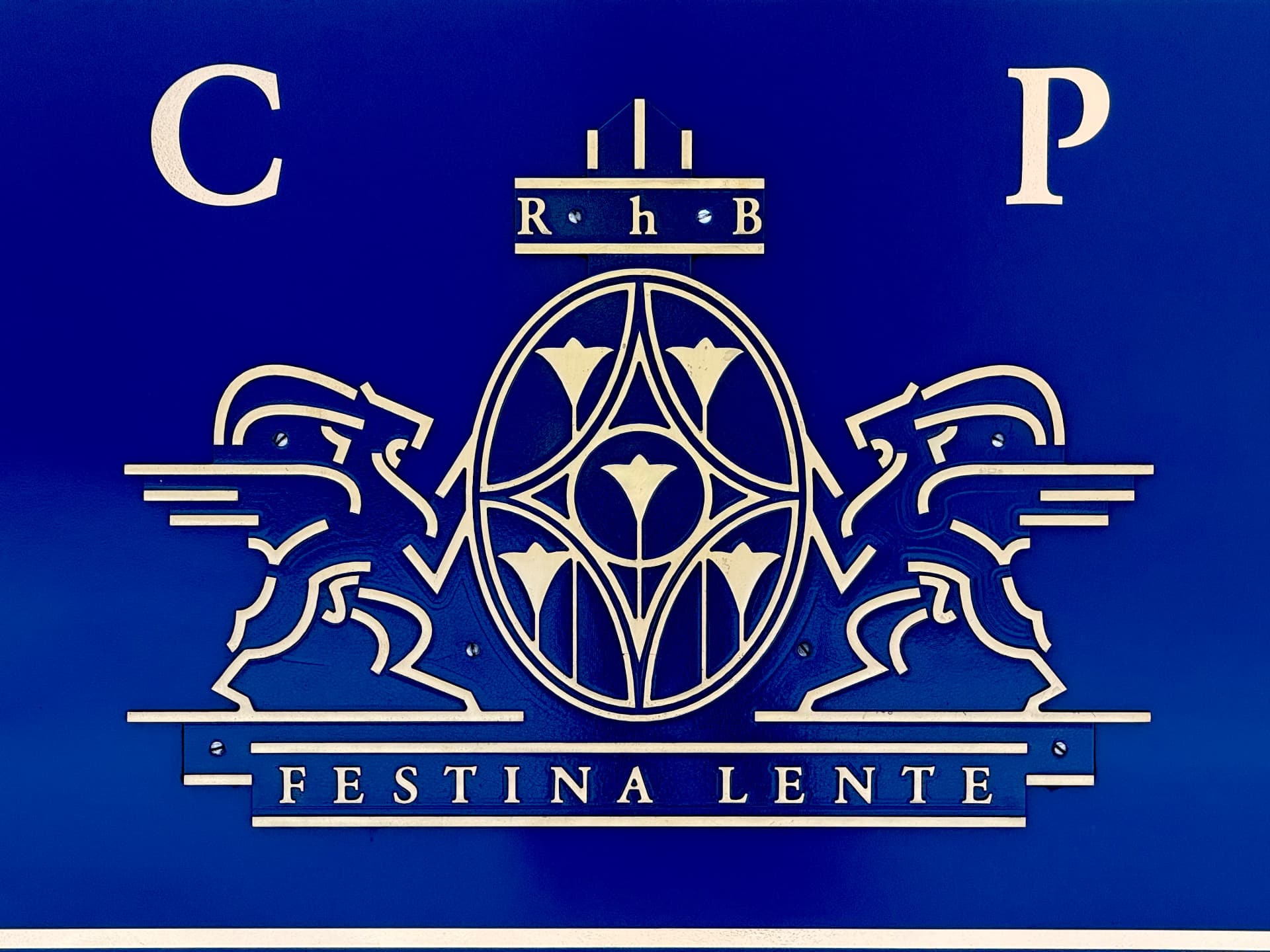 Gold Rhaetian Railway crest with two ibex and the motto Festina Lente on a deep blue panel