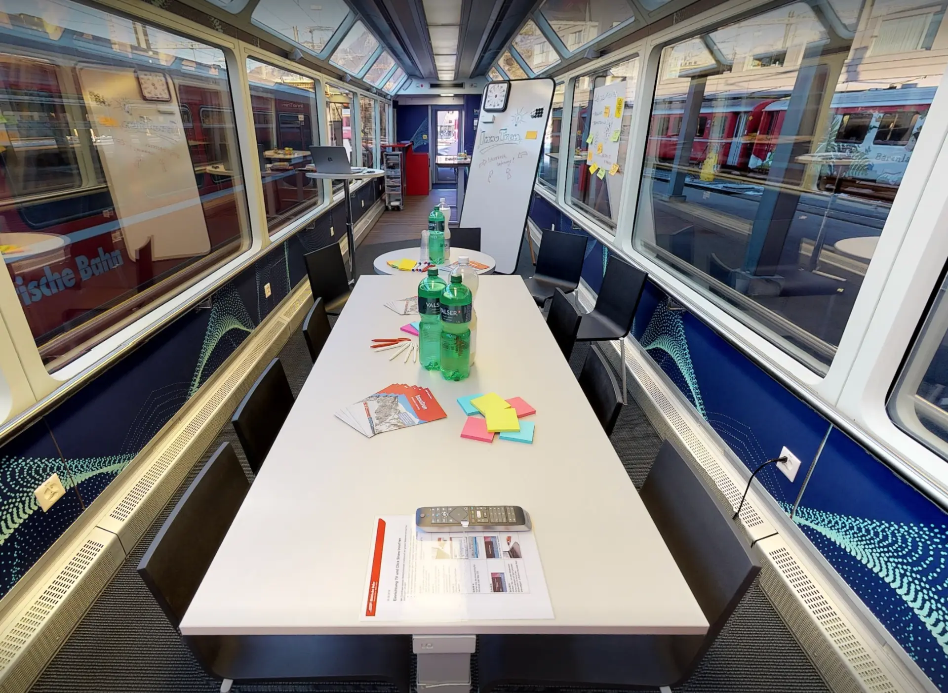 Panorama wagon set up as a boardroom, long white table with chairs beneath the glass roof windows