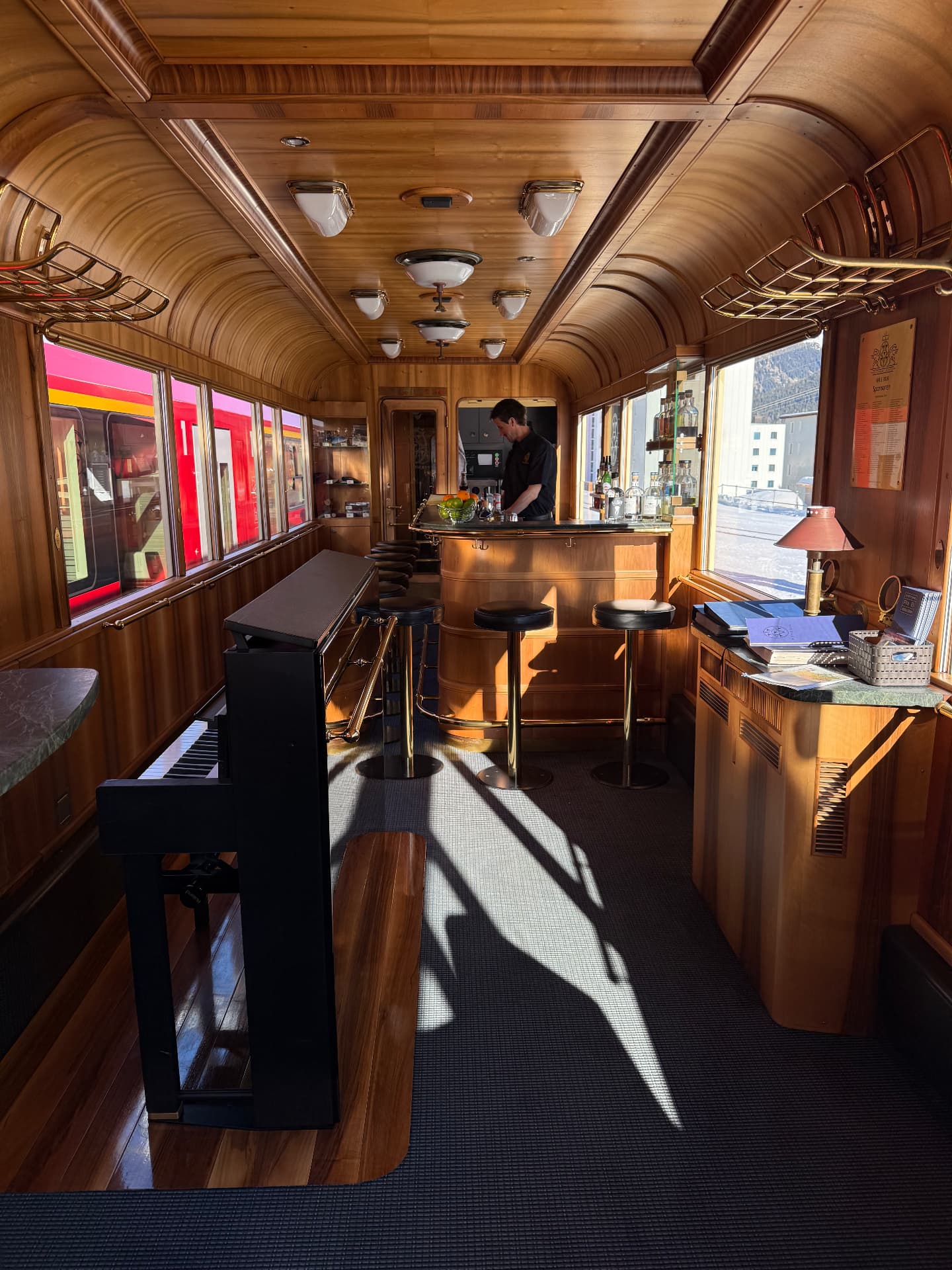 Piano Bar in winter daylight, sunlight across the carpet and a bartender at the counter