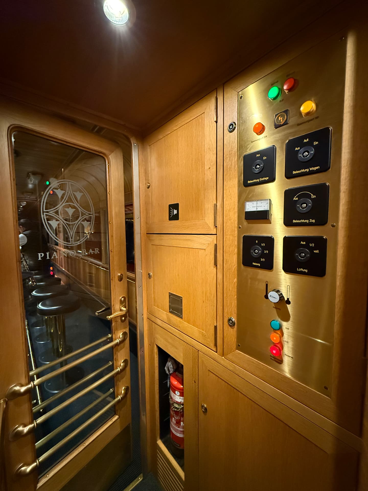 Etched Piano Bar door beside the original brass control panel in the carriage vestibule